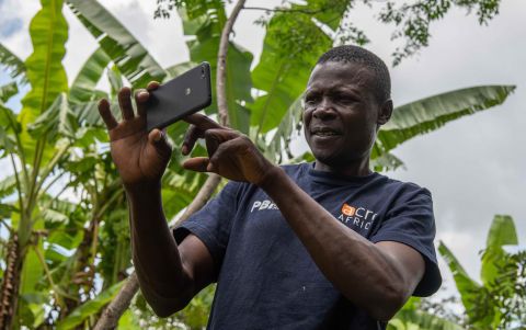 Farmer John Poi Namanjelie shoots a photo of his crop with the Picture-Based Insurance app near Bungoma in Western Kenya. The online service now offers targeted advisories from extension experts based on the images.